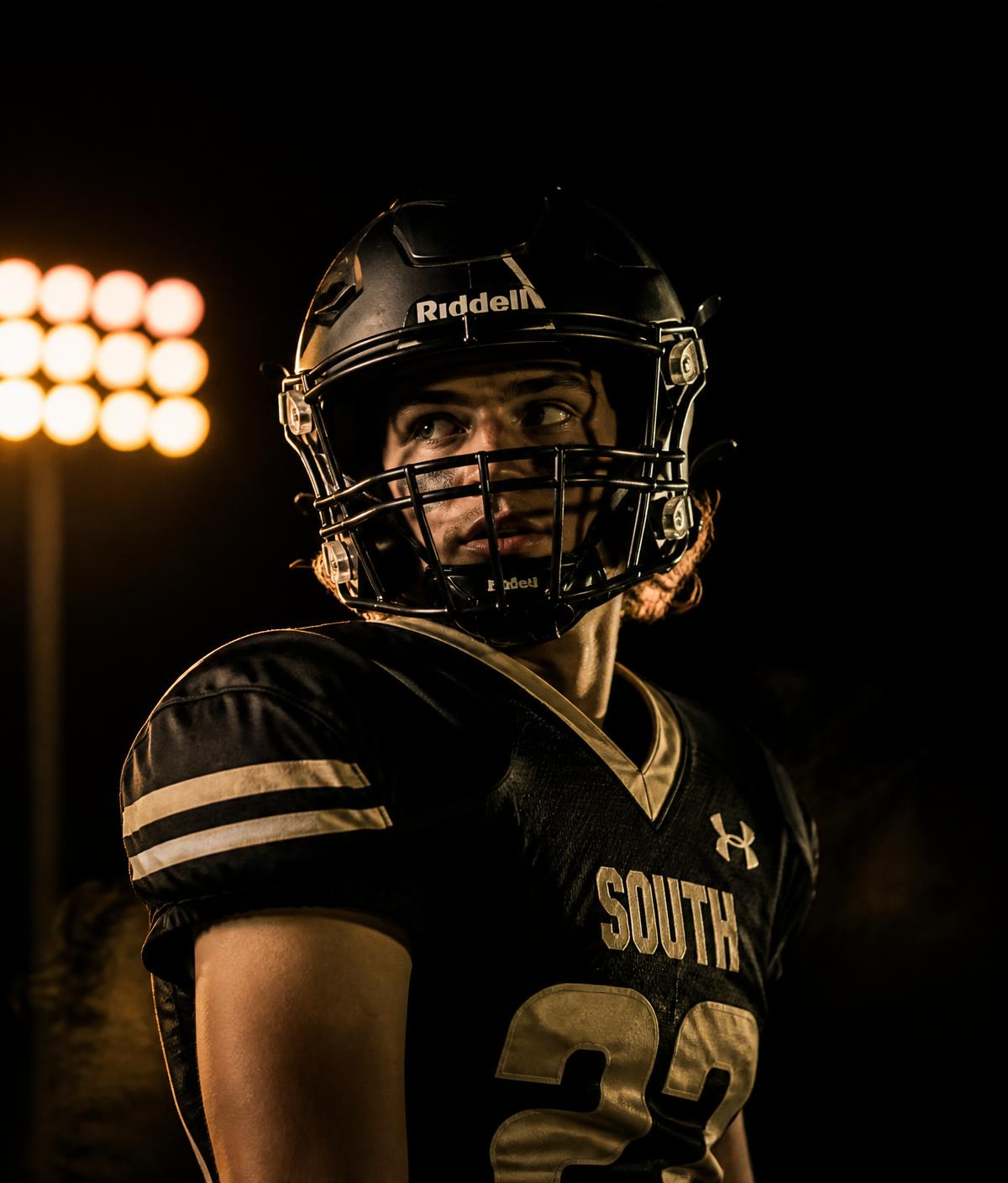 High school football athlete under stadium lights